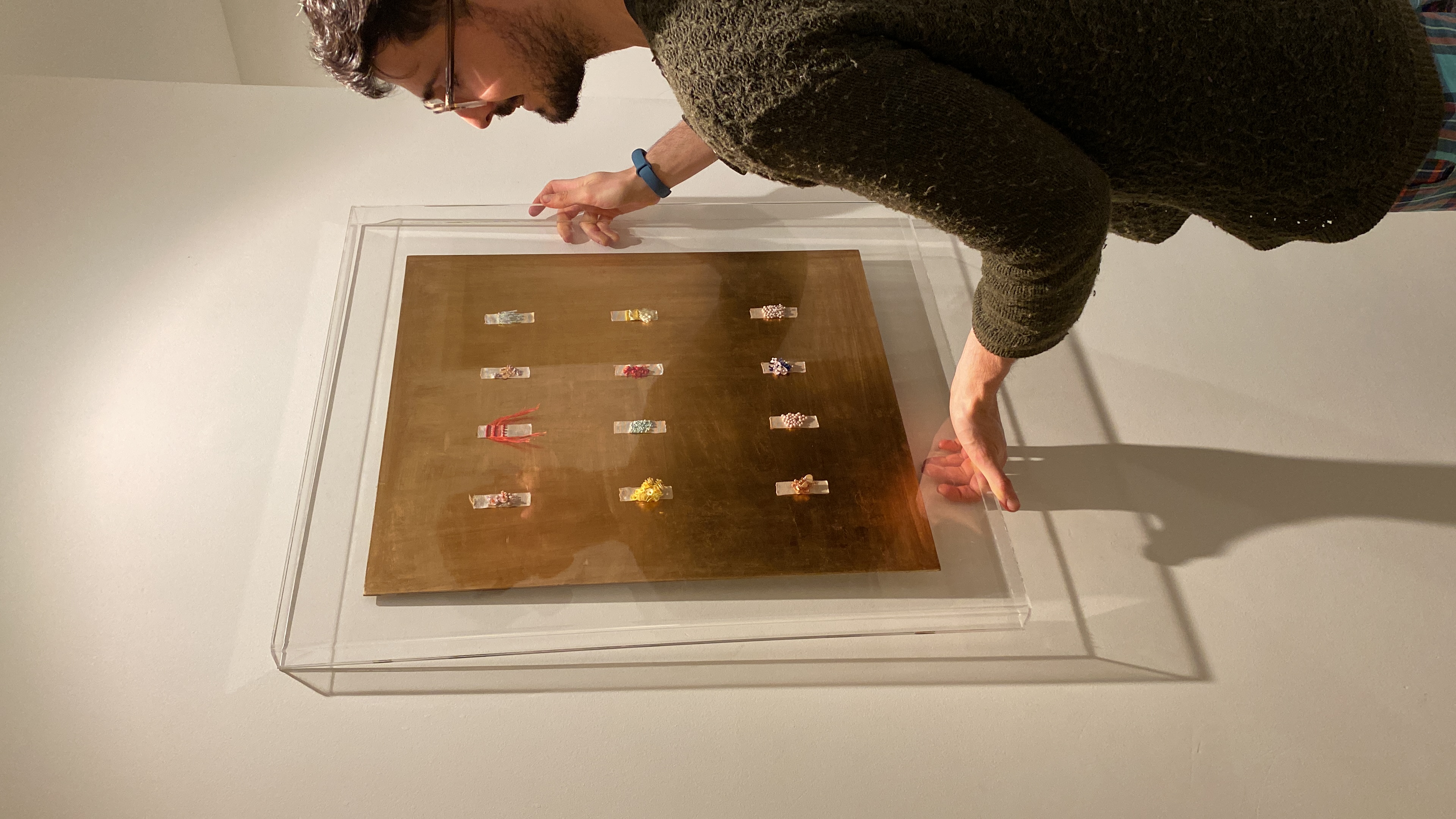 Extreme close-up of hand-embroidered miniature showing individual thread stitches and texture