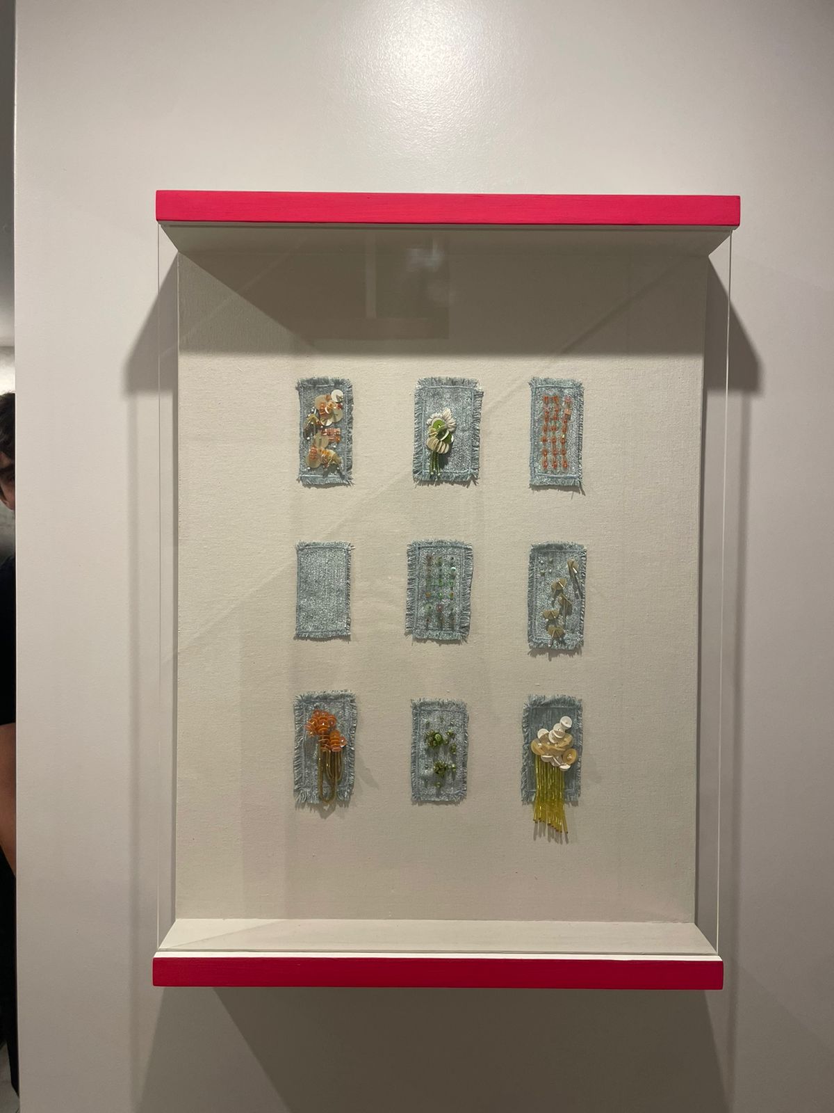 Hand-embroidered miniature of a dress mounted in an open acrylic box, available from the studio