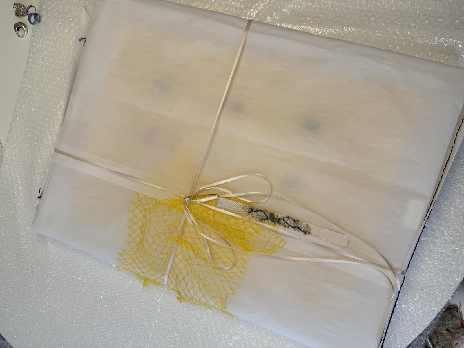 Finished piece wrapped in yellow net, ready to ship